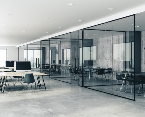 Clean, professional office environment with glass walls and tech setup.