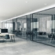 Clean, professional office environment with glass walls and tech setup.