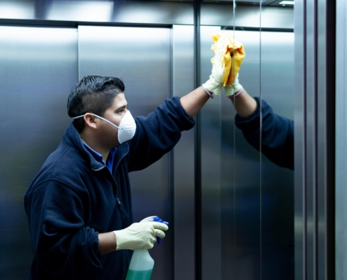 Cleaning staff disinfecting elevator