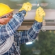 Commercial worker changing electrical socket in ceiling