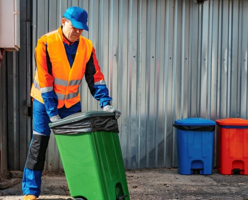 Janitor taking out garbage bins