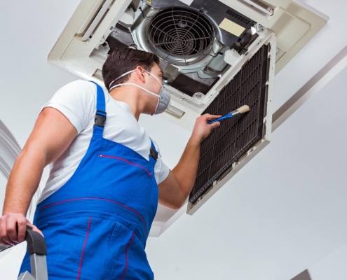 person cleaning vents in office